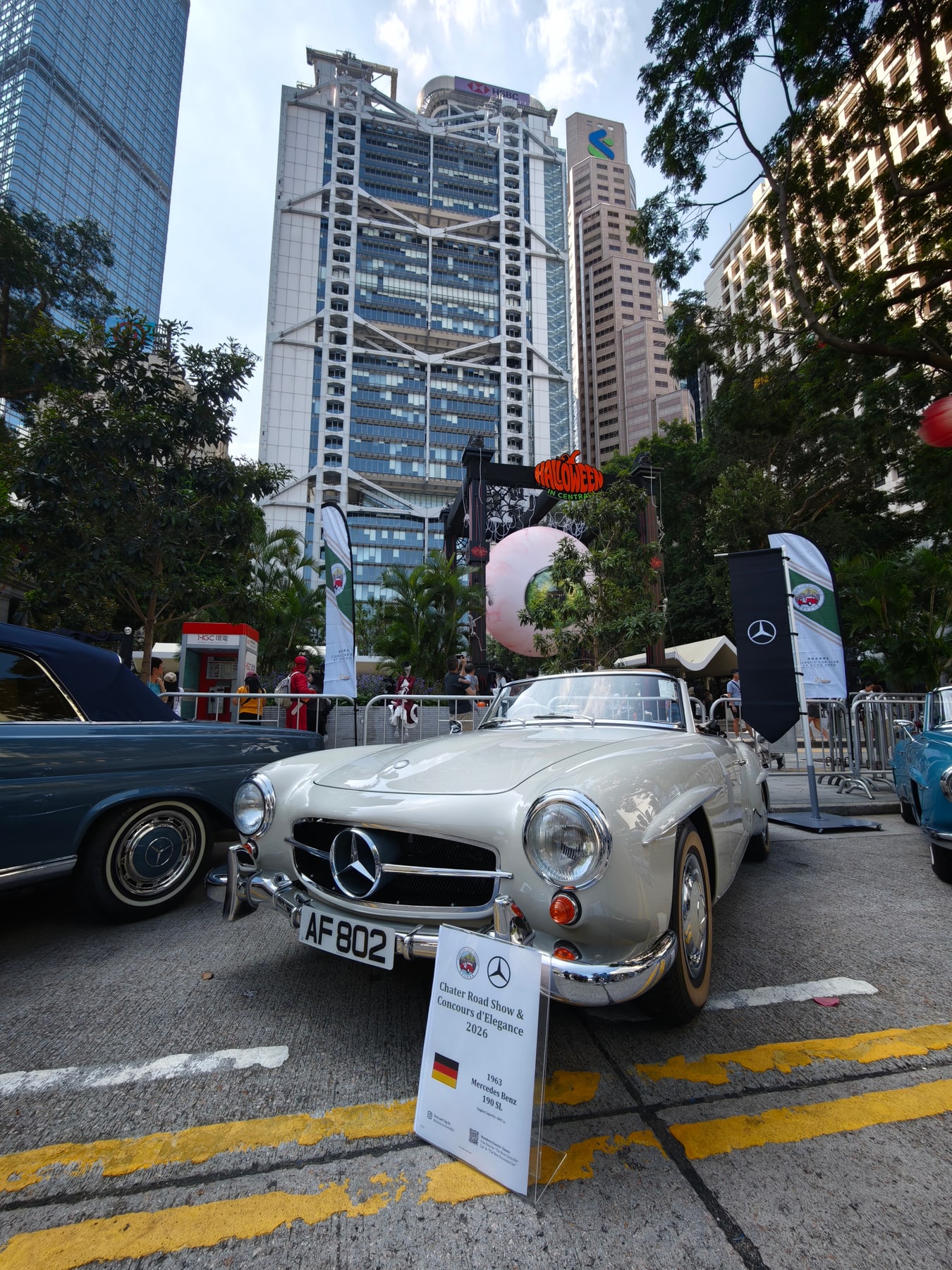HSBC本店ビルを背景に、チャーターロードに展示された銀色のメルセデス・ベンツ190 SL。手前の展示札には1963年と書かれている