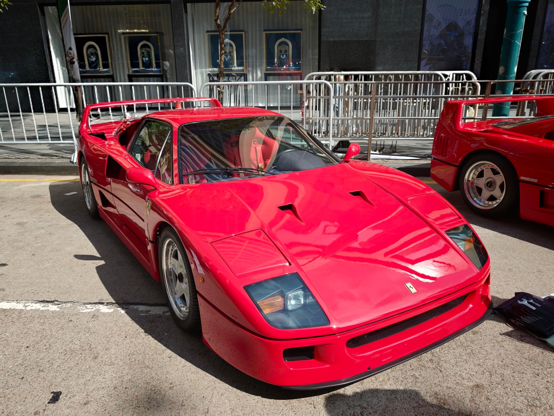 手前の赤いフェラーリF40を斜め前から写した一枚。右隣にも、もう一台の赤いF40の後部が見える