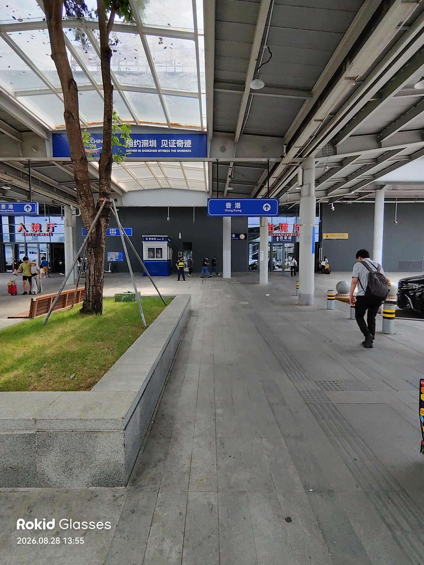 現役プレハブイミグレの構内。「入境厅」「出境厅」の赤い表示と「香港 Hong Kong ↑」の案内、頭上に『相约深圳 见证奇迹』の横断幕。