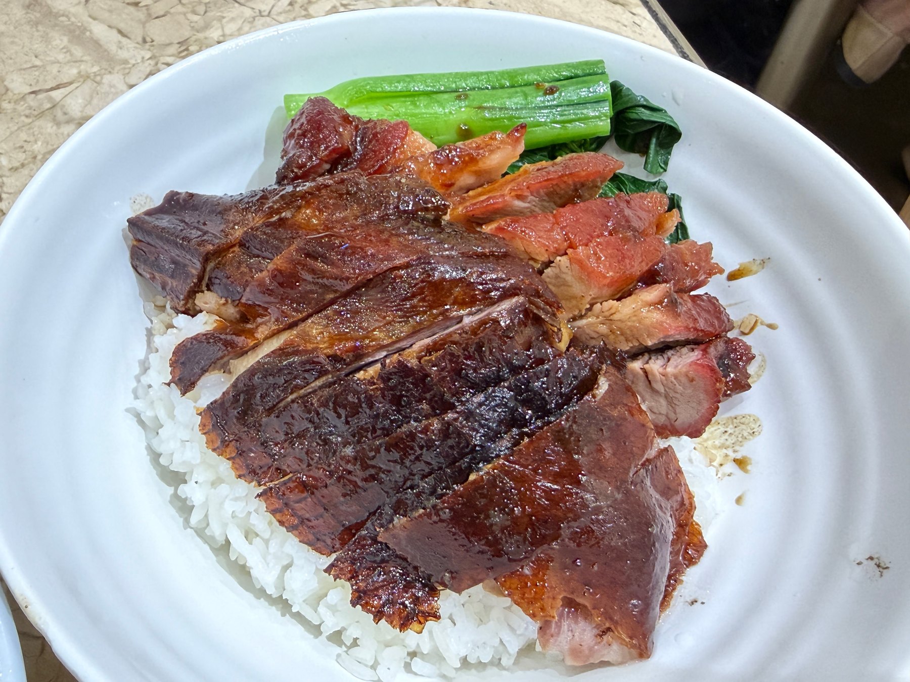白飯の上に照りの出た燒鵝と縁の紅い叉燒が並び、菜心が添えられた双拼飯