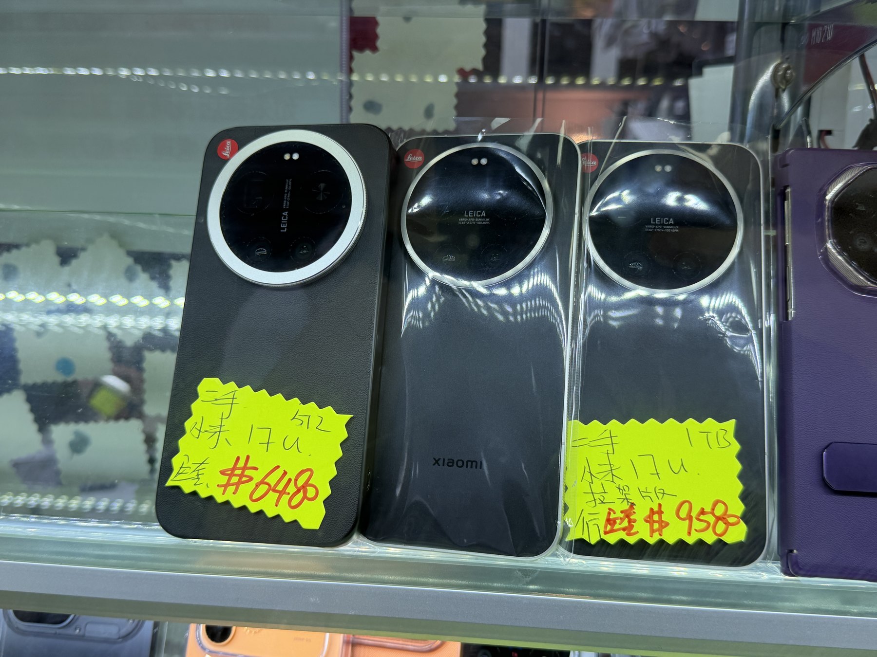 ショーケースに並ぶ黒いXiaomi 17 Ultra。Leica銘のカメラリングと、手書きの黄色い値札