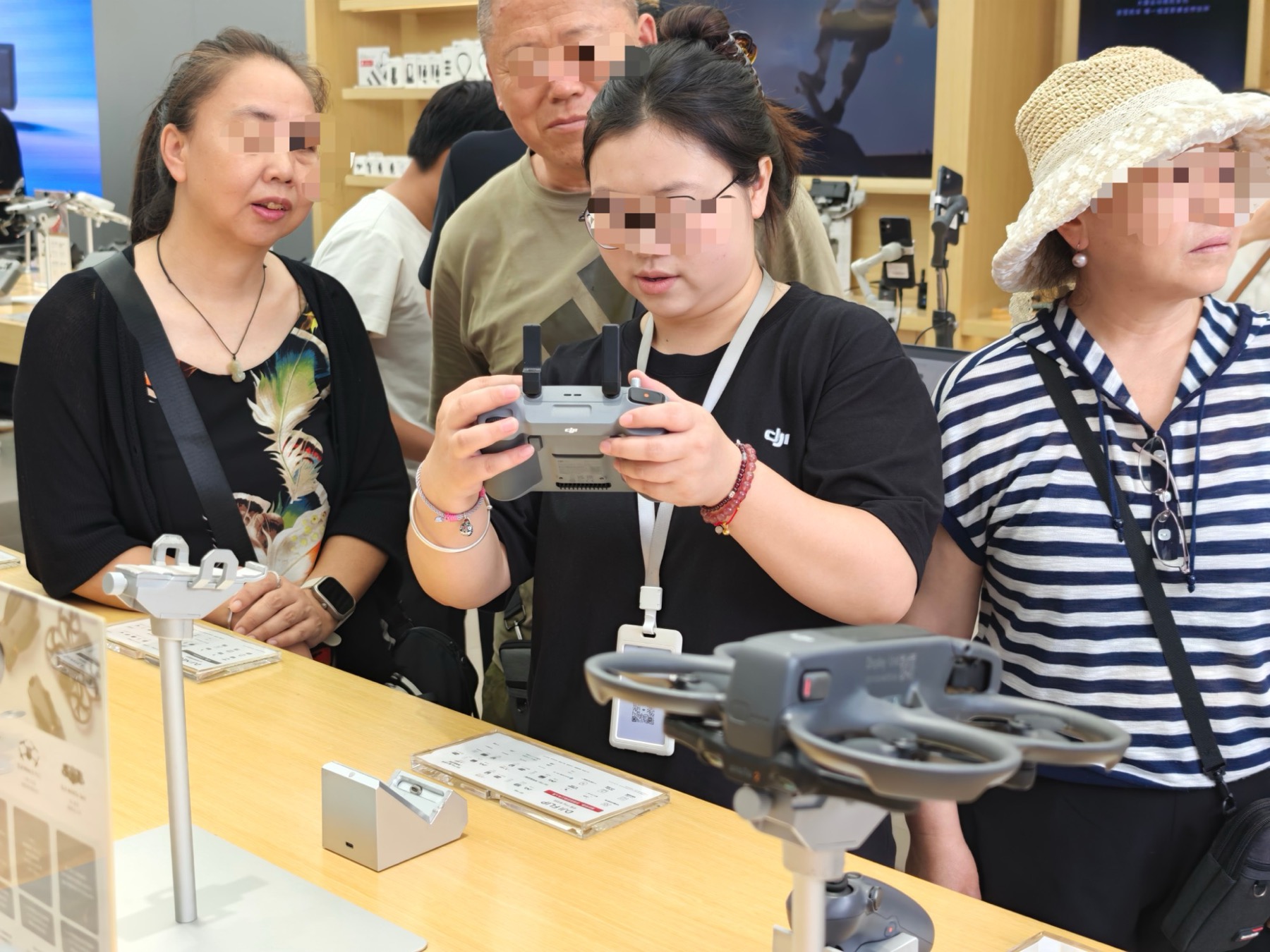 DJIの店内で送信機を手にFlipのデモをする店員と、見守るお客さんたち