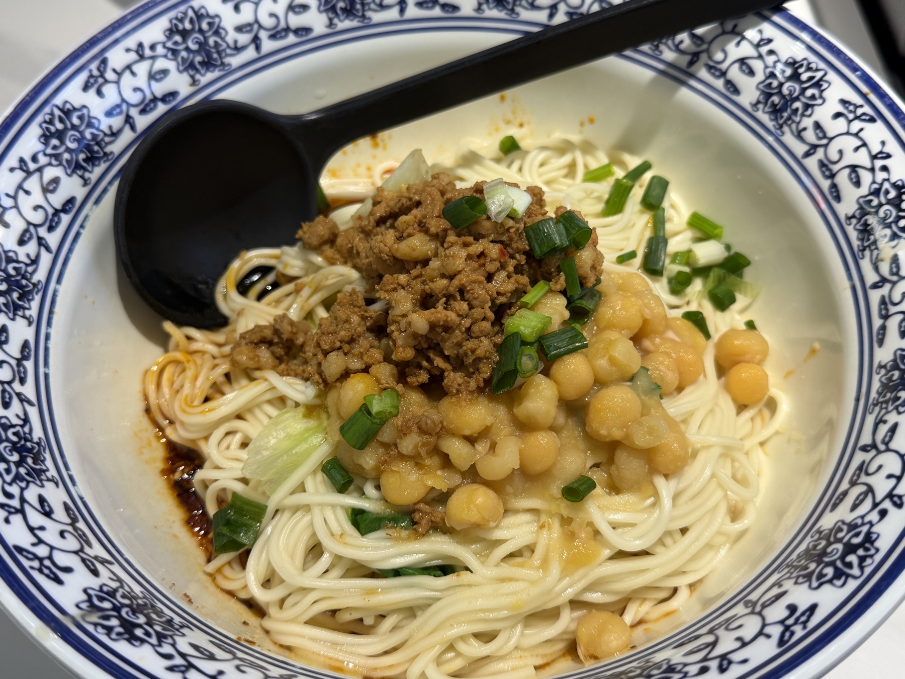 青花模様の丼に盛られた、そぼろと豆をのせた重慶の汁なし麺
