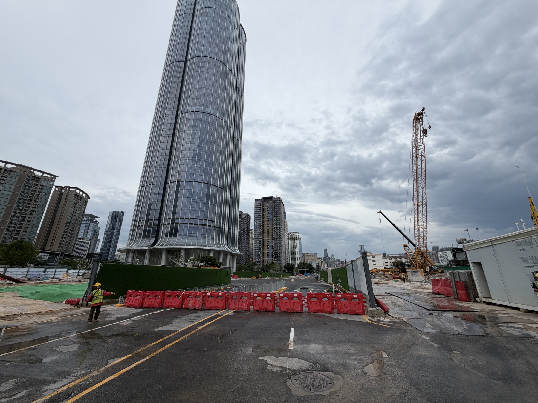 工事中の一角に建つ、深圳の国境近くの丸い高層ビル