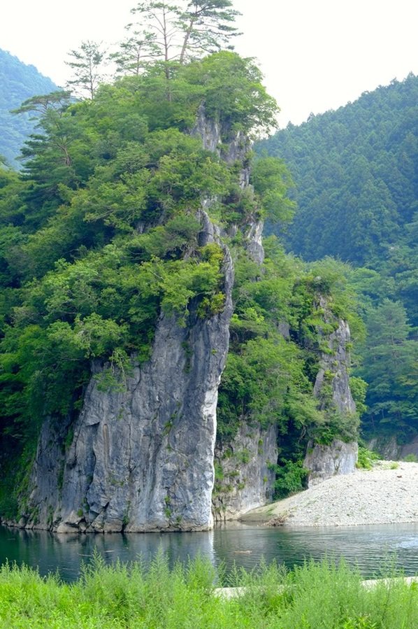 切り立った岩山の下を流れる、澄んだ渓流