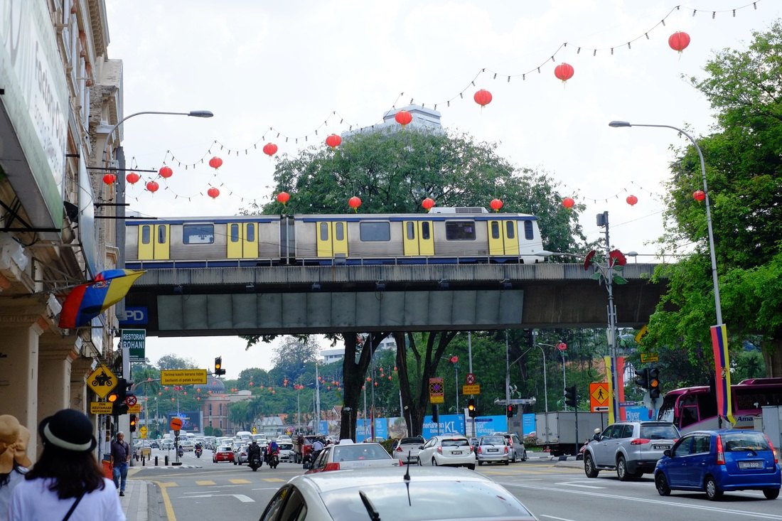 クアラルンプールの通り。高架を電車が走り、上空には赤い提灯が連なって吊るされている