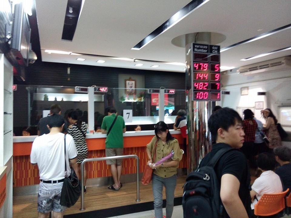 両替店の店内。番号表示のLEDと、カウンターに並ぶ客